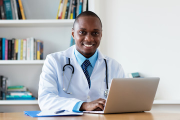 African american chef physician working at computer