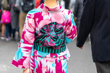 Young girl wearing Japanese kimono standing in front of Sensoji Temple in Tokyo, Japan. Kimono is a Japanese traditional garment. The word "kimono", which actually means a "thing to wear"