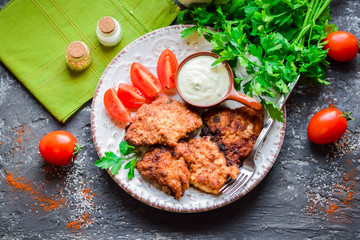 Fried portion chicken with greens and fresh vegetables.