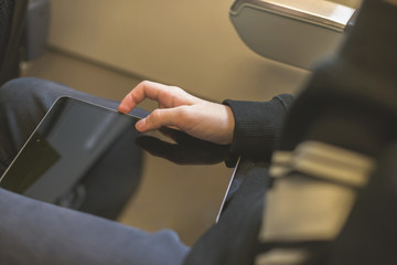 Caucasian boy fasten seat belt and using tablet pc during air flight.  Safety travel with kid. concept