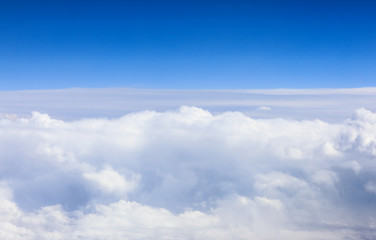Fototapeta na wymiar white clouds in a blue dramatic sky with a view from the plane