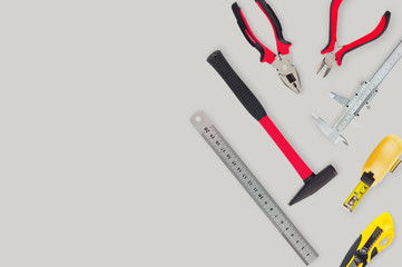 Professional tools for woodworking and metalworking on gray table in workroom. Top view. Building concept. Copy space for your text