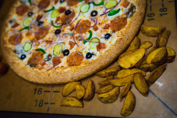A whole big pizza close-up on a gray background. Colorful pizza topping closeup