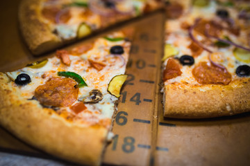 A slice of pizza close-up, appetizing pizza filling, cheese. Hand takes a separate piece of pizza