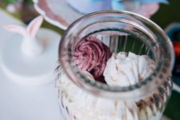 A glass jar in which lies the marshmallow.