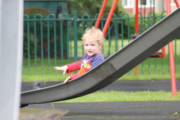 Little boy on the slide at the park