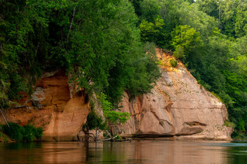 Fototapeta na wymiar Red sandstone cliff on coast of the river