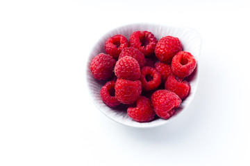Fresh raspberries in ceramic bowl isolated on white background