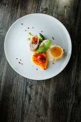 delicious dissected stuffed chicken with pumpkin puree and yellow sauce