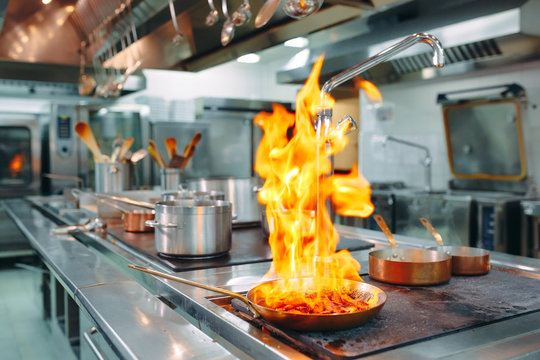 Modern kitchen. Cooks prepare meals on the stove in the kitchen of the restaurant or hotel. The fire in the kitchen.