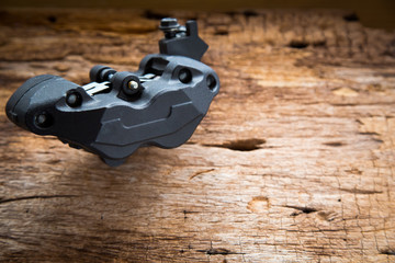 Obraz premium Close up photo of Caliper brake system for big bike on old wood background