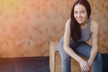 young girl in sportswear in a gym in a simple background, a theme of fitness, and sport