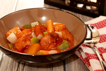Afritada - Filipino cuisine. Chicken Stewed in Tomato Sauce on the table.