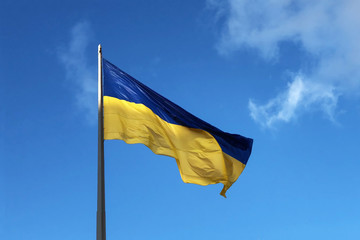 Ukrainian flag fluttering in the wind against a blue sky with clouds. The symbol of presidential elections in Ukraine 2019.