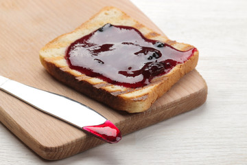toasts with jam. fried crispy toasts with red jam on a white wooden table.