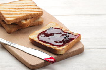 toasts with jam. fried crispy toasts with red jam on a white wooden table.