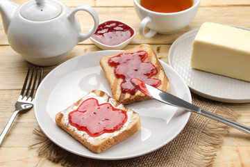 toasts with jam. fried crispy toast with red jam on a natural wooden table. breakfast.
