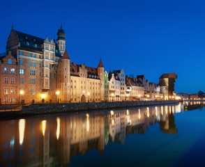 Fototapeta na wymiar Old town in Gdansk, Poland at night. Riverside with the famous Crane and city reflections in the Motlava river. High resolution panorama.