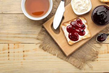 toasts with jam. fried crispy toast with red jam on a natural wooden table. breakfast. top view
