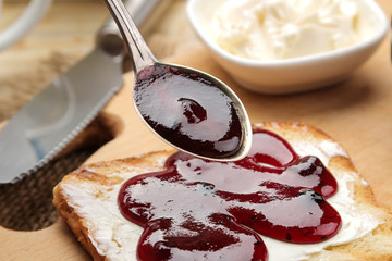 toasts with jam. fried crispy toast with red jam on a natural wooden table. breakfast. close-up