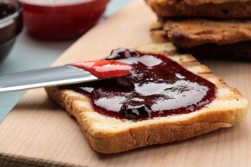 toasts with jam. fried crispy toast with red jam on a blue wooden table. breakfast. close-up