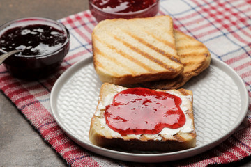 toasts with jam. fried crispy toast with red jam on a dark background. breakfast.