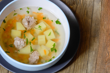 Vegetable soup with chicken cutlets and pieaces of homemade bread.Side view with copy space.