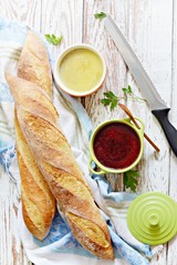 Fresh crispy French baguette with chicken liver pate and berry marmalade on a white aged background. Fresh homemade chicken pate on bread 