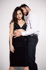 sexy woman in black bra standing with handsome bearded man on white