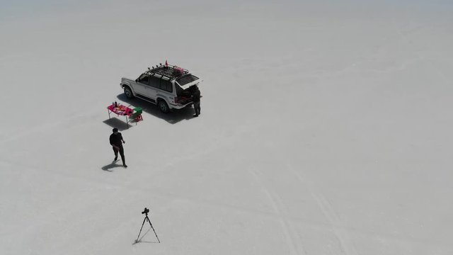 Aerial drone footage Preparing Lunch and and taking photos in Salar de Uyuni Bolivia Biggest natural mirror in the world