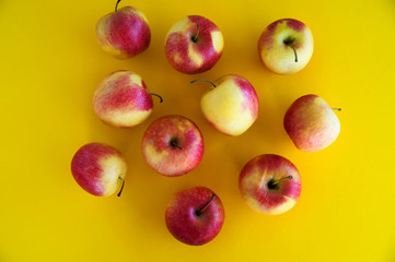 Yellow-red juicy fresh apples lie on a yellow background. Fresh fruit from the garden.diet