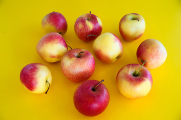 Yellow-red juicy fresh apples lie on a yellow background. Fresh fruit from the garden.  Diet.