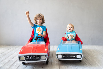 Children superheroes playing at home
