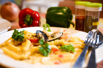Macaroni cheese and seafood on a white plate. Italian food.