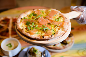 Slice of hot pizza cheese lunch or dinner crust seafood meat topping sauce with bell pepper vegetables delicious tasty fast food italian traditional on wooden board table classic with delivery hand 