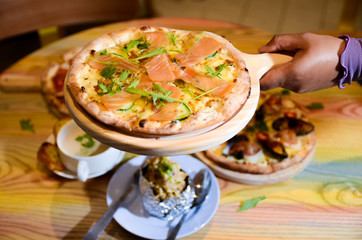 Slice of hot pizza cheese lunch or dinner crust seafood meat topping sauce with bell pepper vegetables delicious tasty fast food italian traditional on wooden board table classic with delivery hand 