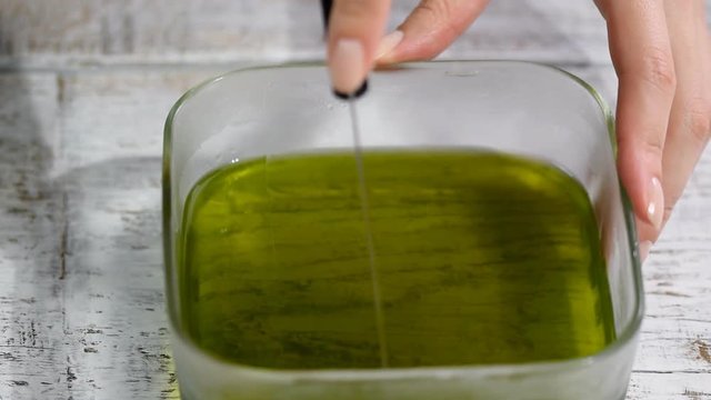 Female hands cutting the green jelly into pieces.