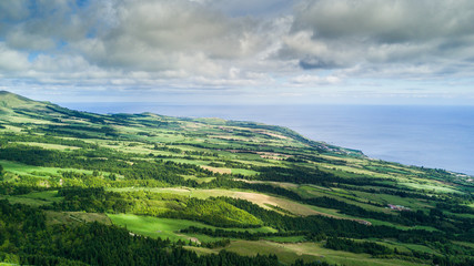 Fototapeta premium Aerial view on scenic landscape of volcano and green fields around it. Special shape of ground. Top view from drone. Azores islands, Sao Miguel, Portugal.