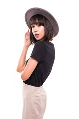 Fototapeta premium Trendy young woman in hat wearing casual clothes posing over white background