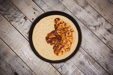 Round pizza dough is in the pan. The process of cooking pizza, stacking ingredients on the dough.