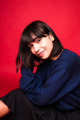 Fototapeta premium Young pretty brunette woman portrait isolated on red background