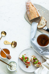 Breakfast: toasts, honey cup of tea and baguette. Top view. copy space.