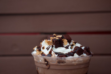 Iced chocolate drink decorated with whipped cream and brownies