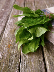 bundle of spinach on a wooden background and linen napking