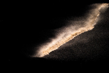 Fototapeta na wymiar Dry river sand explosion. Brown color sand splash against black background.