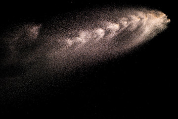 Abstract river sand cloud. Golden colored sand splash against black background.