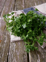 bundle of parsley on a wooden background and linen napking