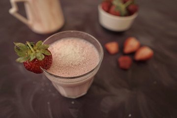 Fresh strawberry smoothie or milkshake and berries on purple background. Summer vibes. Healthy Eating concept