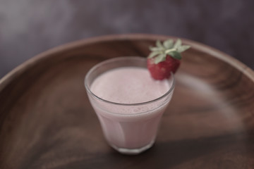 Strawberry milkshake or smoothie with fresh berries on wooden 