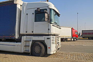 Fototapeta na wymiar Various types of trucks in the parking lot next to the motorway.